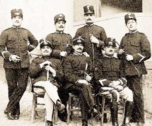 Gruppo di militari della specialità a cavallo fotografati nell'interno di una scuderia.